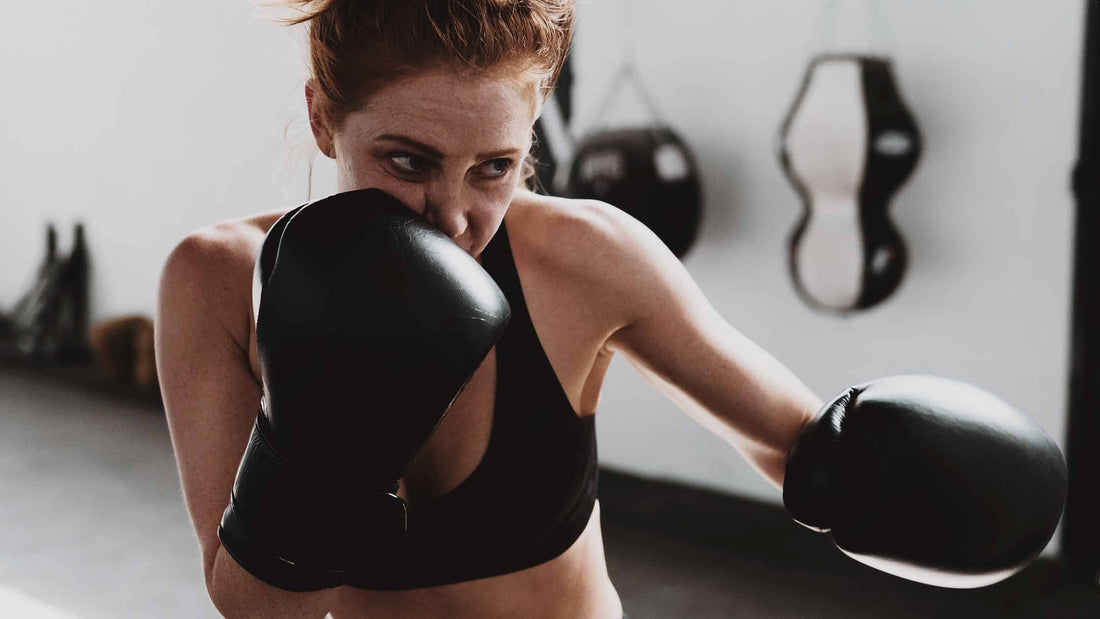 Slim woman hitting a heavy bag, showing the spirit of Keep Fighting