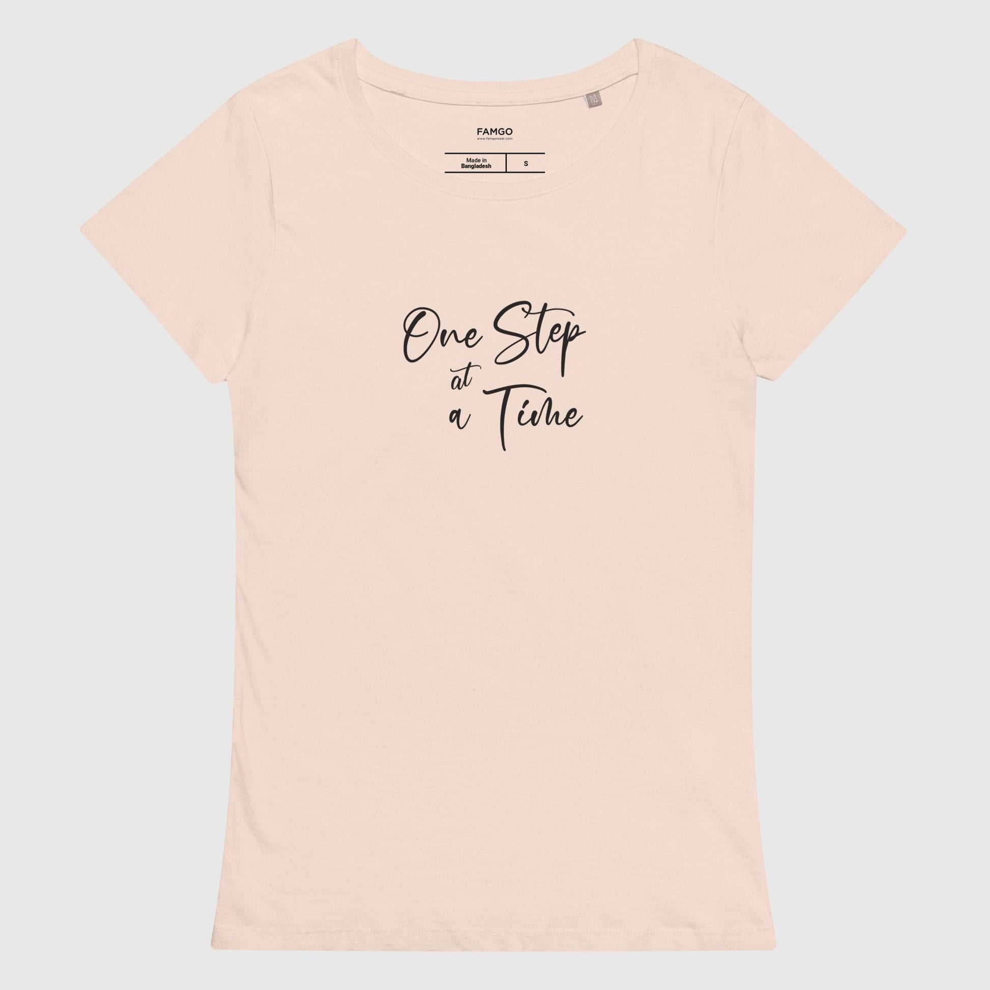 Women's creamy pink organic cotton t-shirt that features the inspirational quote, "One Step At A Time."
