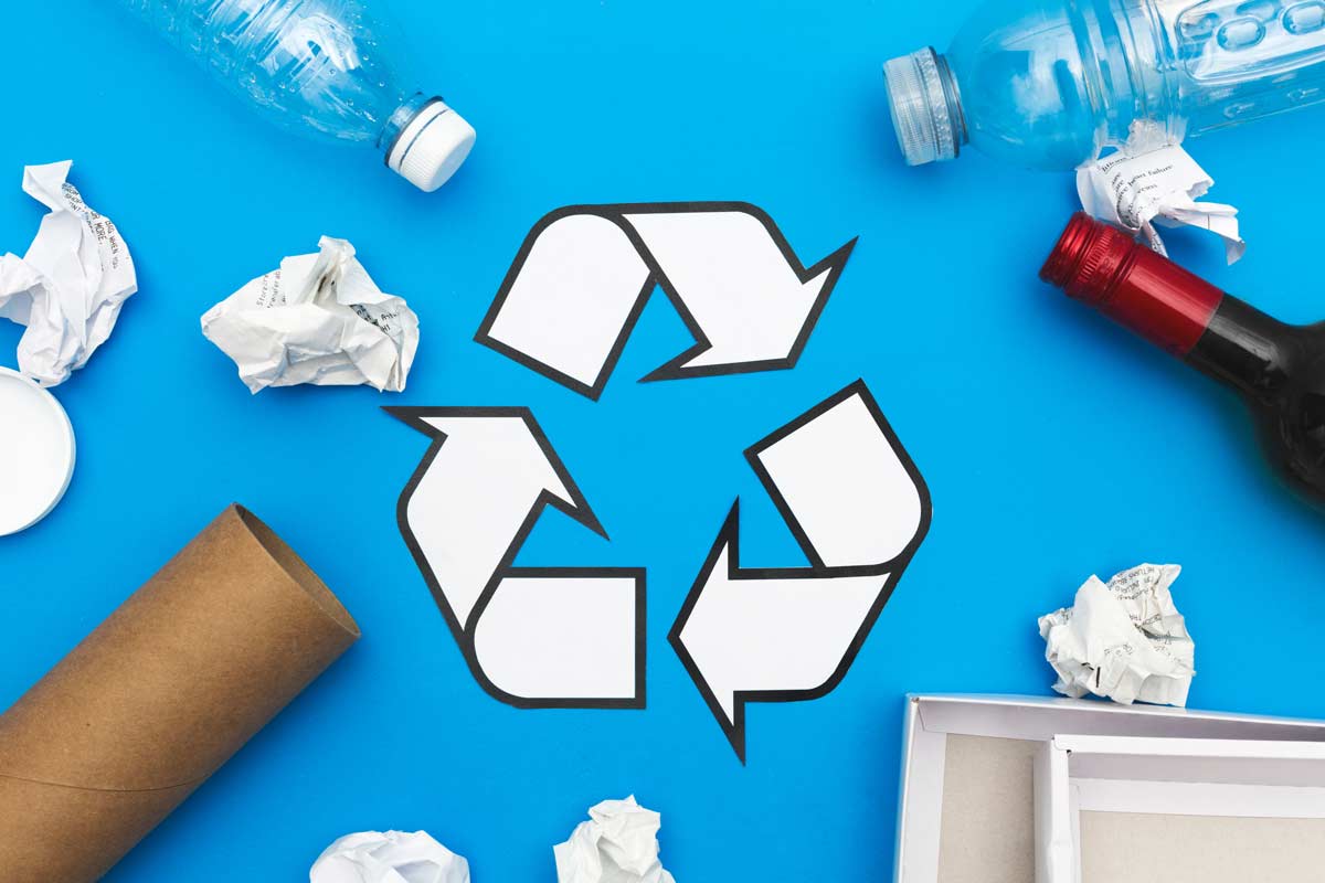 Recycle symbol with plastic bottles, used paper roll, crumbled papers
