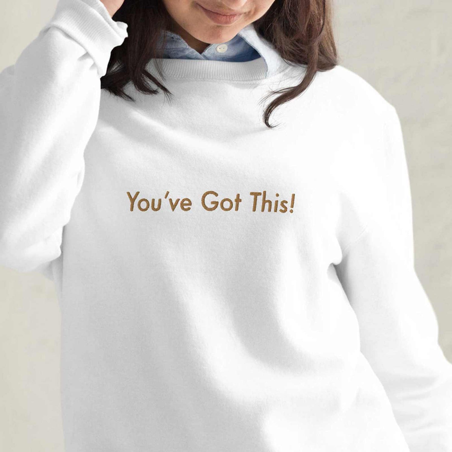 Woman wearing a "You've Got This!" white sweatshirt