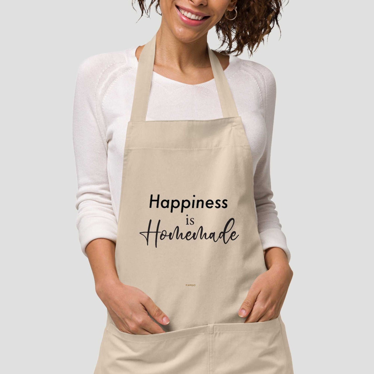 Close-up view of a beige "Happiness is Homemade" inspirational quote 100% organic cotton apron